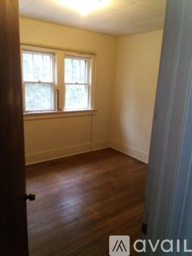A room with a window and wooden floors.