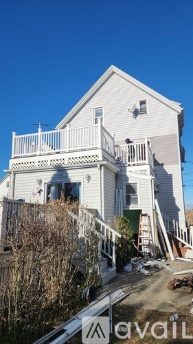 A house with a balcony and a ladder in front of it.