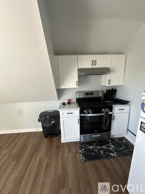 A kitchen with white cabinets and a black stove top.
