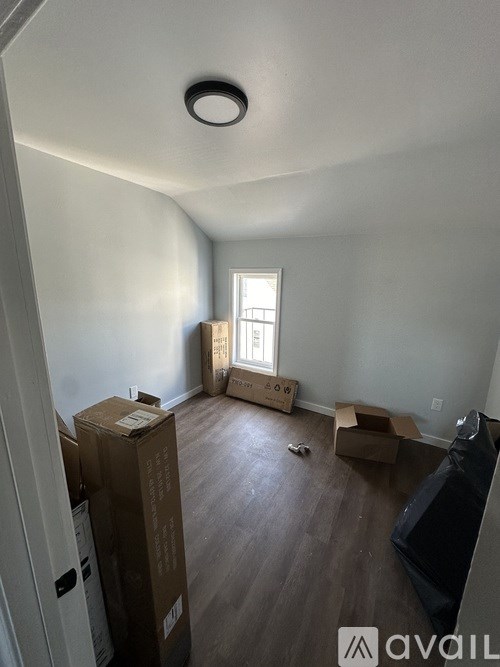 A room with boxes and a black couch.