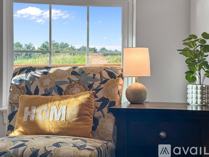 A living room with a couch, a lamp, and a pillow with the word "HOME" on it.