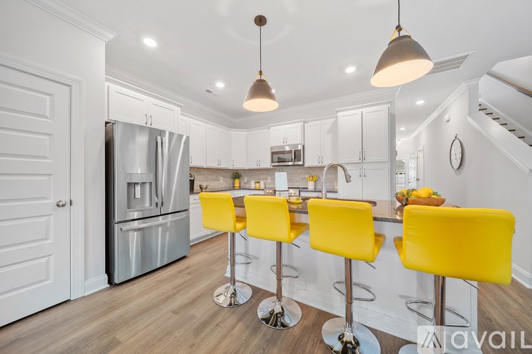 A kitchen with a bar area featuring yellow stools.