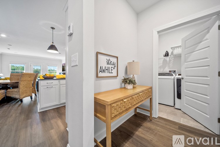 A kitchen with a wooden table and a framed poster on the wall.