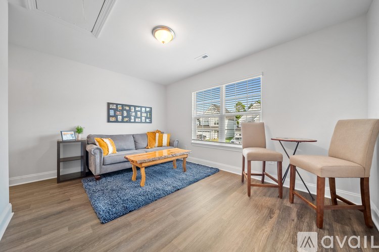 A living room with a grey couch, a wooden coffee table, and a blue rug.