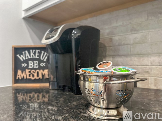 A coffee maker and a decorative bowl with stickers on it.