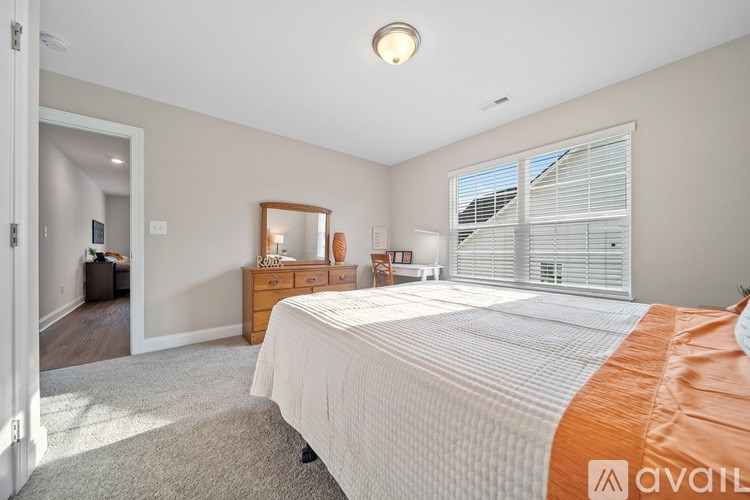 A bedroom with a bed, dresser, and mirror.
