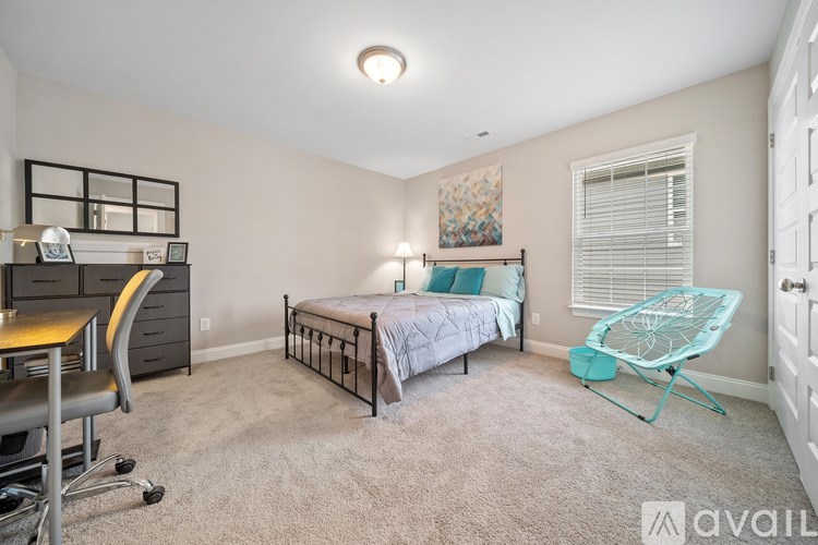 A bedroom with a bed, desk, and chair.