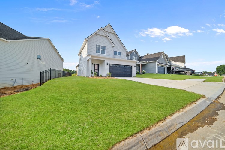A white house with a black fence in front of it.
