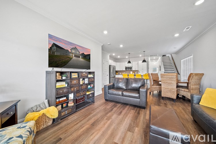 A living room with a large painting on the wall and a variety of furniture.