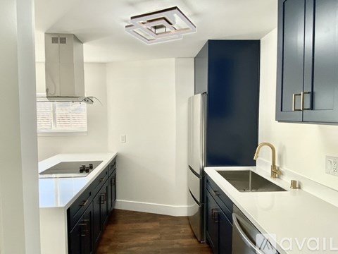 A kitchen with a white counter top and black cabinets.
