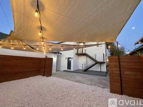 A patio area with a white canopy and string lights.