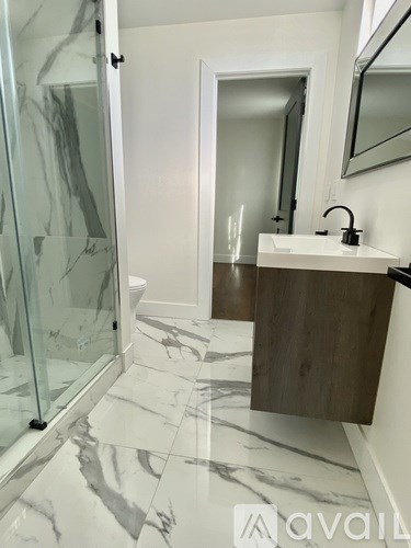 A bathroom with marble flooring and a walk-in shower.