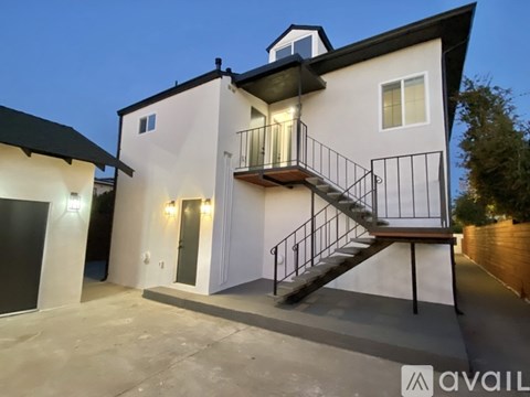 A modern house with a balcony and a staircase leading to the second floor.