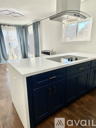 A kitchen with dark blue cabinets and a white countertop.