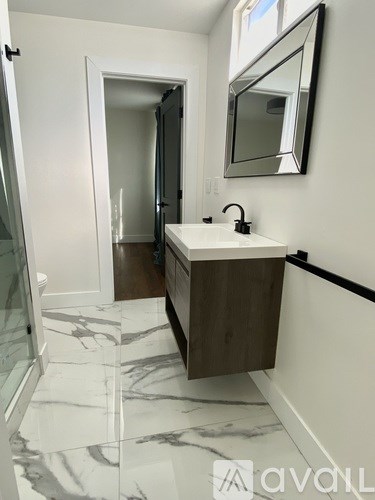 A bathroom with a marble floor and a wooden cabinet.