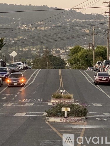 Cars are driving on a road with a crosswalk in the middle.