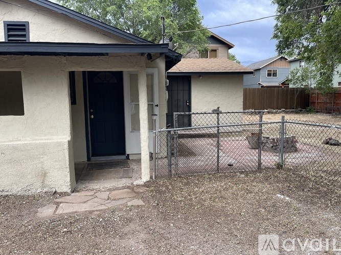 A house with a black door and a fence in front.