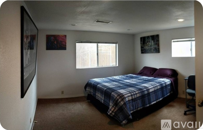 A carpeted room with a door and a mirror on the wall.