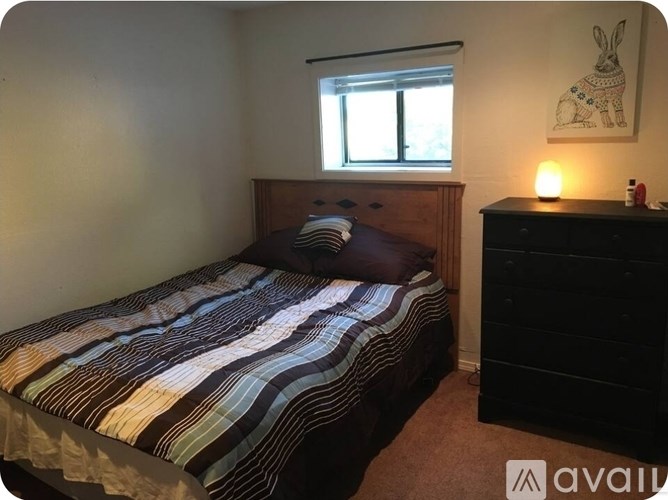 A white bed with a mattress in a room with a white door.