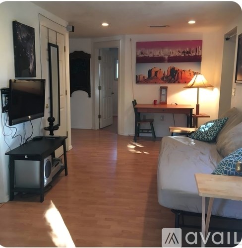A living room with a couch, television, and a painting on the wall.