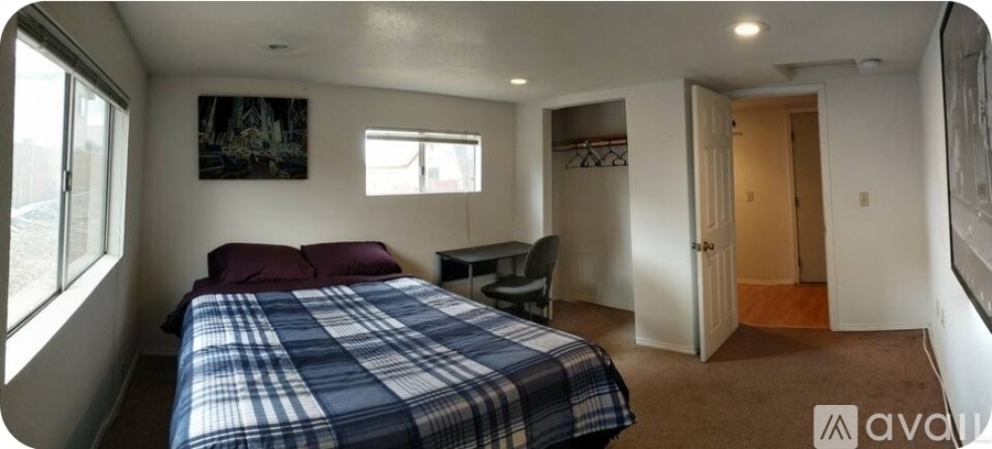 A bedroom with a bed, chair, and closet.