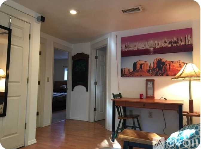 A room with a desk and a chair in front of a large picture of a city skyline.