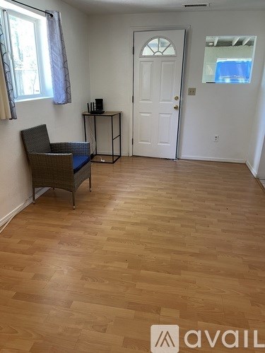 A room with wooden flooring and a chair.