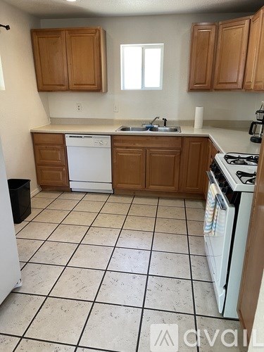 A kitchen with white appliances and brown cabinets.