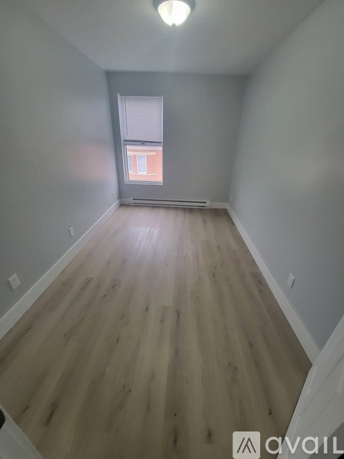 A room with wooden flooring and a window.