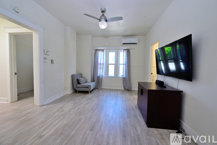 A living room with a television, a chair, and a ceiling fan.
