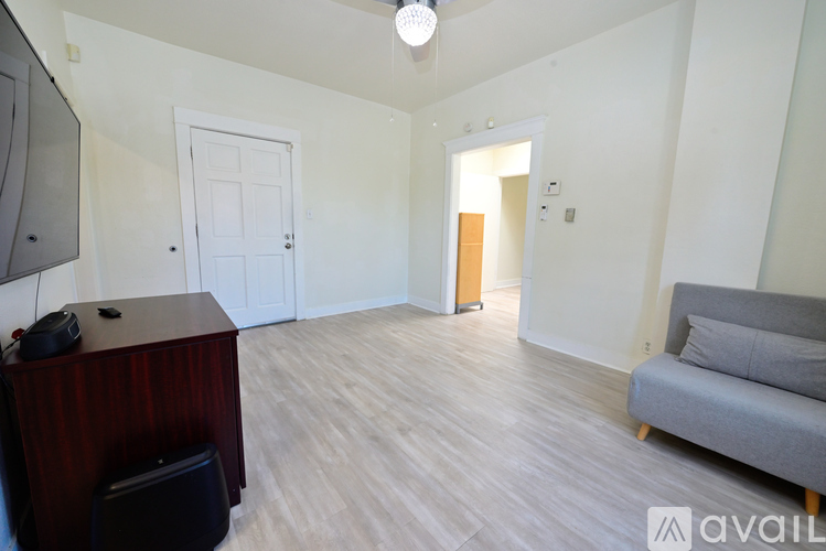 A living room with a grey couch and a wooden cabinet.