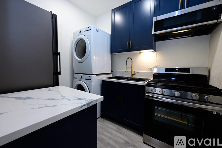 A kitchen with dark blue cabinets and a white marble countertop.