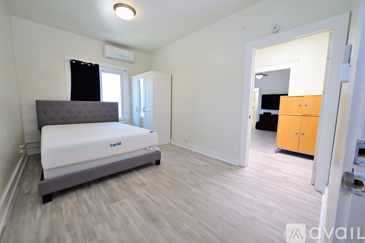 A bedroom with a bed, a window, and a closet.