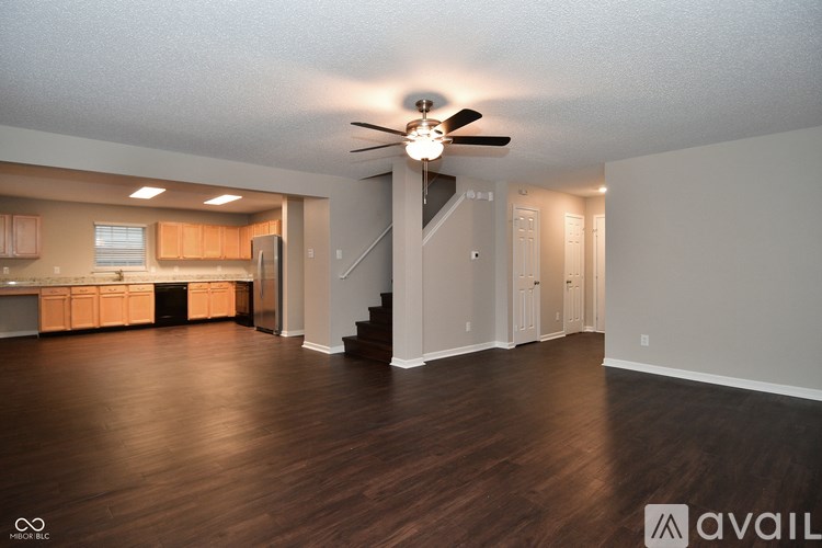 A spacious living room with wood flooring and a ceiling fan.