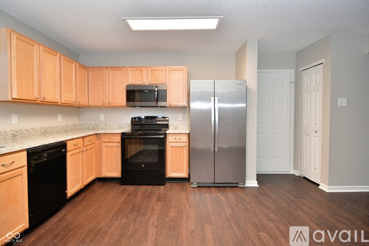 A kitchen with wooden cabinets and a stainless steel refrigerator.