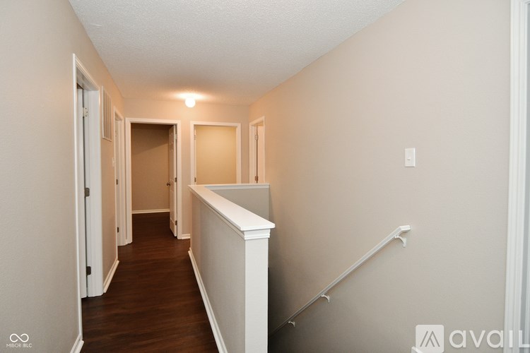 A long hallway with a white railing on the right side.