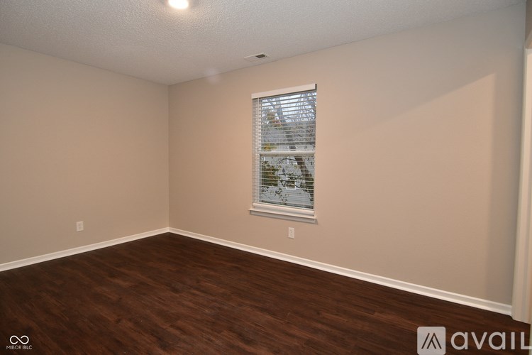 A room with a window showing a view of a snowy landscape.