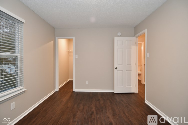 A room with a white door and a window with blinds.