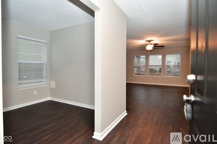 A room with wooden floors and a ceiling fan.