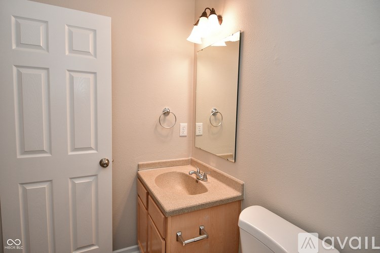 A bathroom with a sink, mirror, and toilet.