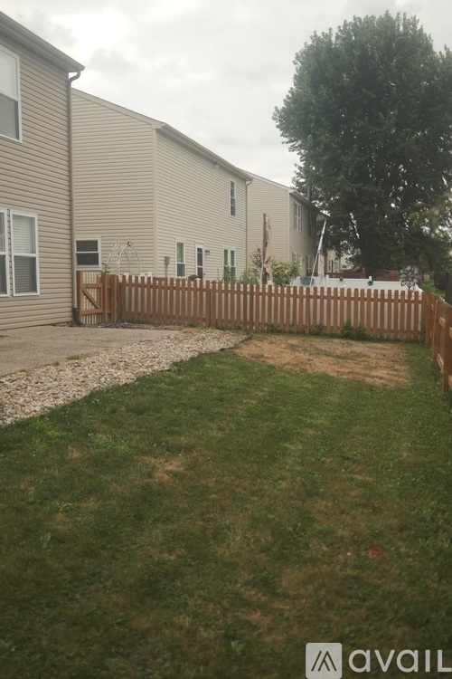 A grassy area in front of a building with a wooden fence.