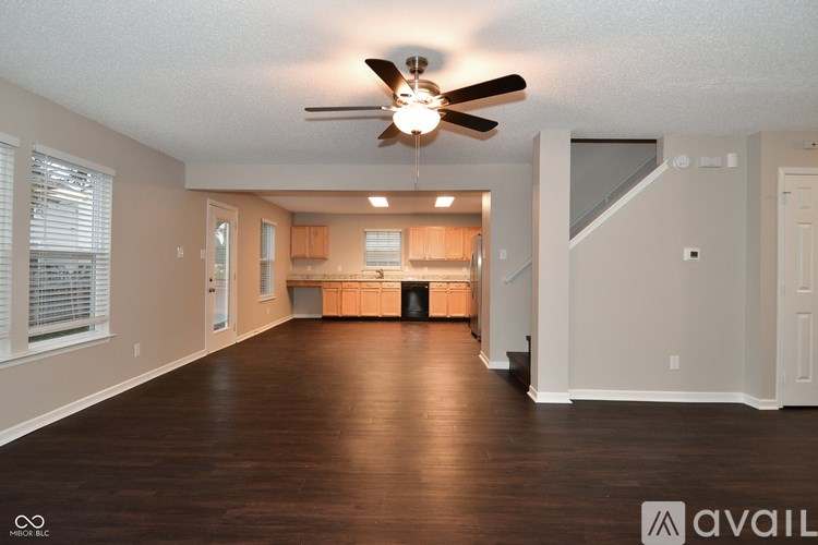 A spacious room with a ceiling fan and wooden flooring.