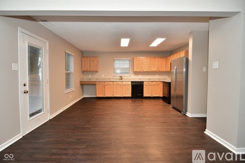 A kitchen with wooden cabinets and a refrigerator.