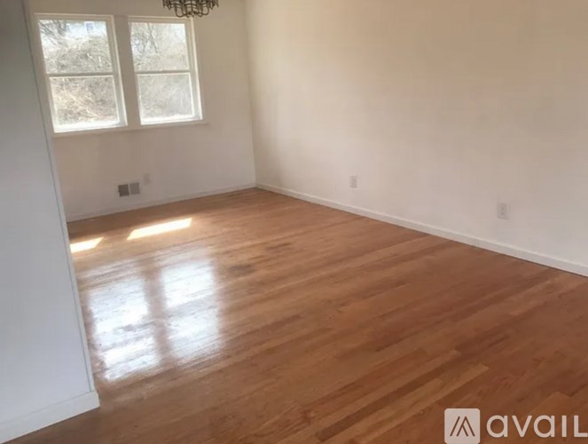 A room with wooden flooring and a window.