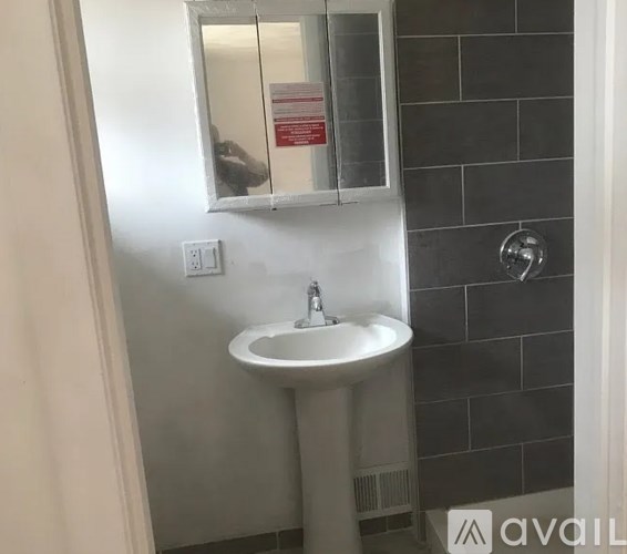 A white sink in a bathroom with a mirror above it.