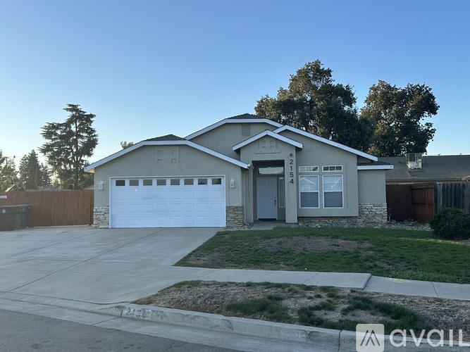 A house with a garage and a driveway in front of it.