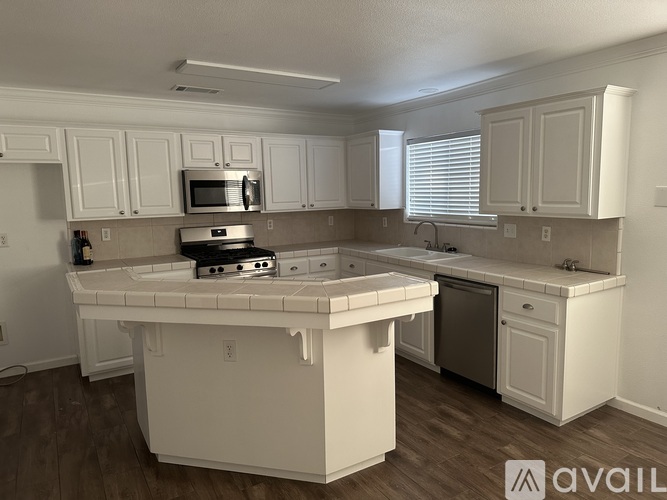 A kitchen with white cabinets and a white island.