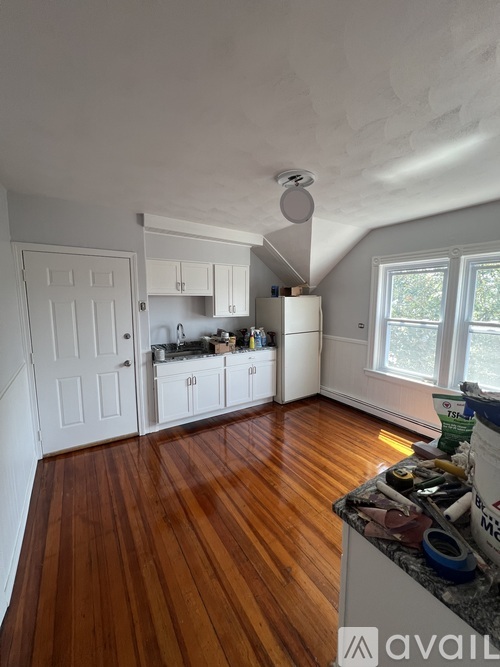 A kitchen with wooden floors and white walls.