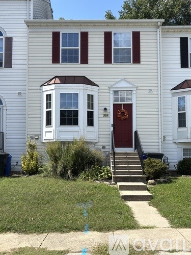 A white house with a red door and a small porch.