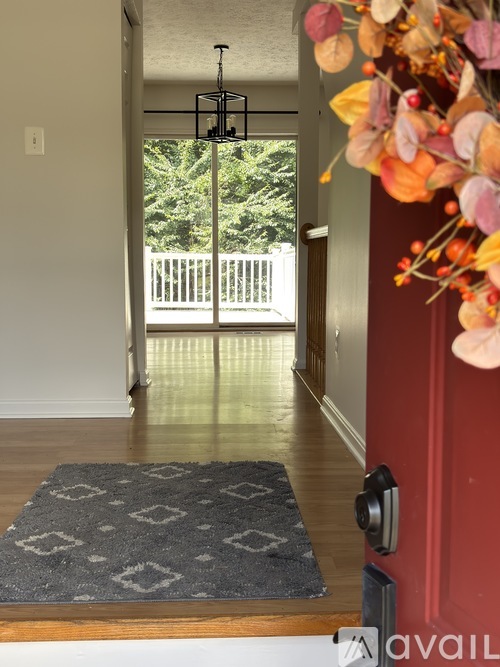 A hallway with a rug and a flower decoration.